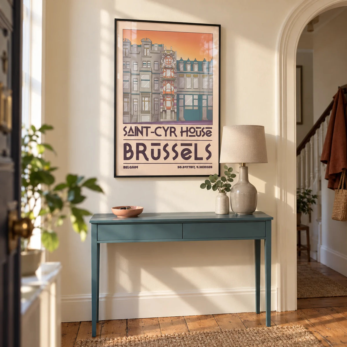 Saint Cyr House Poster, framed on the wall of a welcoming entrance hallway in a UK city maisonette with pale cream walls and restored timber floorboards