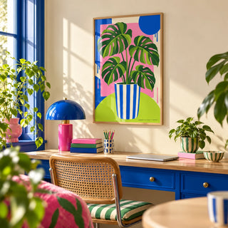 Striped Pot Monstera Print, framed on the wall of a cheerful home office