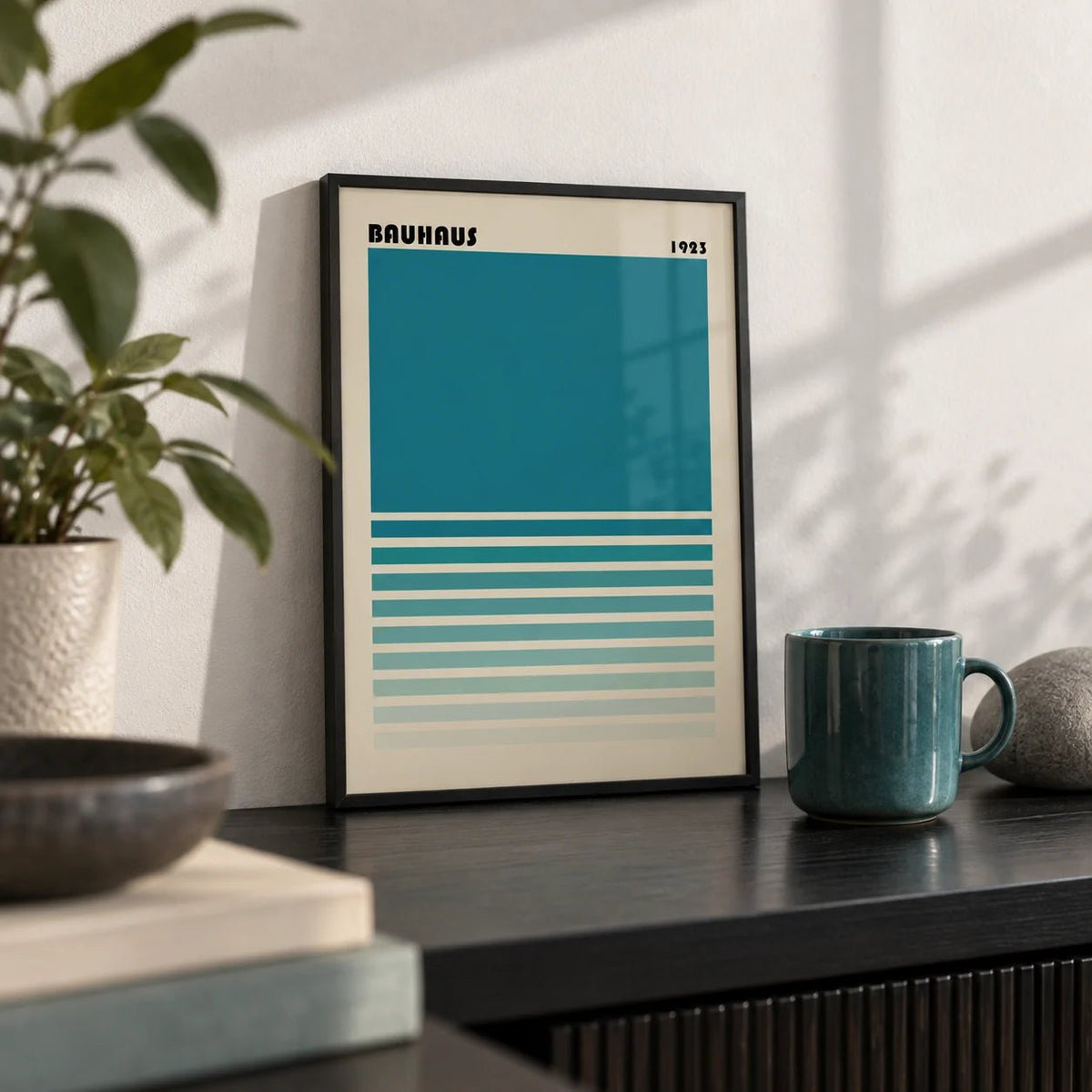 Teal Blue Gradient Wall Art, a small A4 framed print leaning on a black shelf in a living room