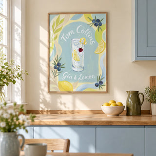 Tom Collins Art Print, framed on the wall of a bright kitchen in a UK terraced house with pale blue painted cabinets