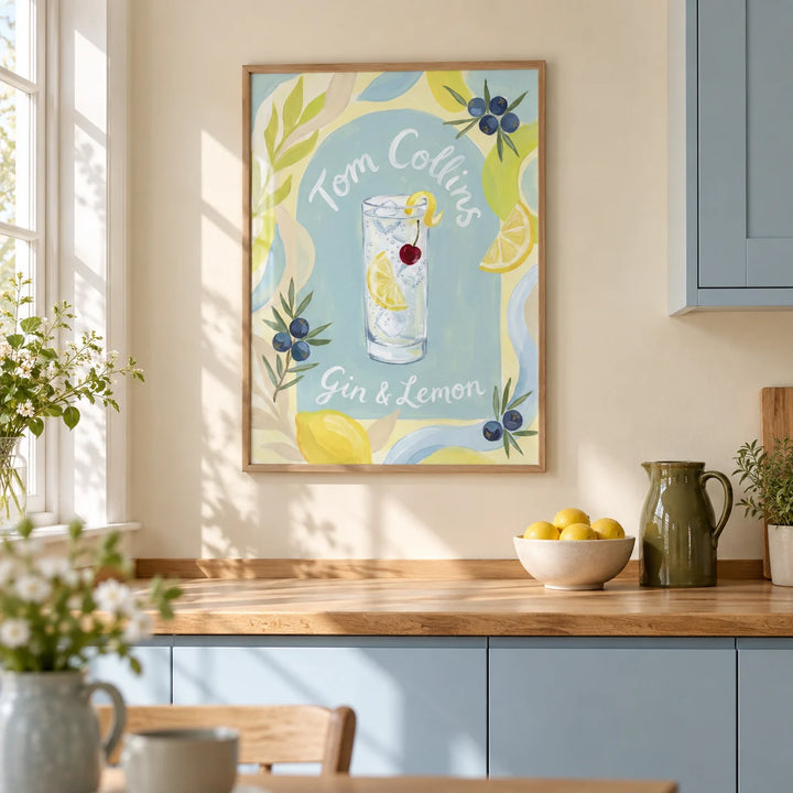 Tom Collins Art Print, framed on the wall of a bright kitchen in a UK terraced house with pale blue painted cabinets