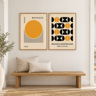 Yellow and Black Bauhaus Prints Set of 2 hung at eye level above an oak bench in a hallway: Golden Dawn and Bauhaus Symmetry shown framed side by side (frames not included)