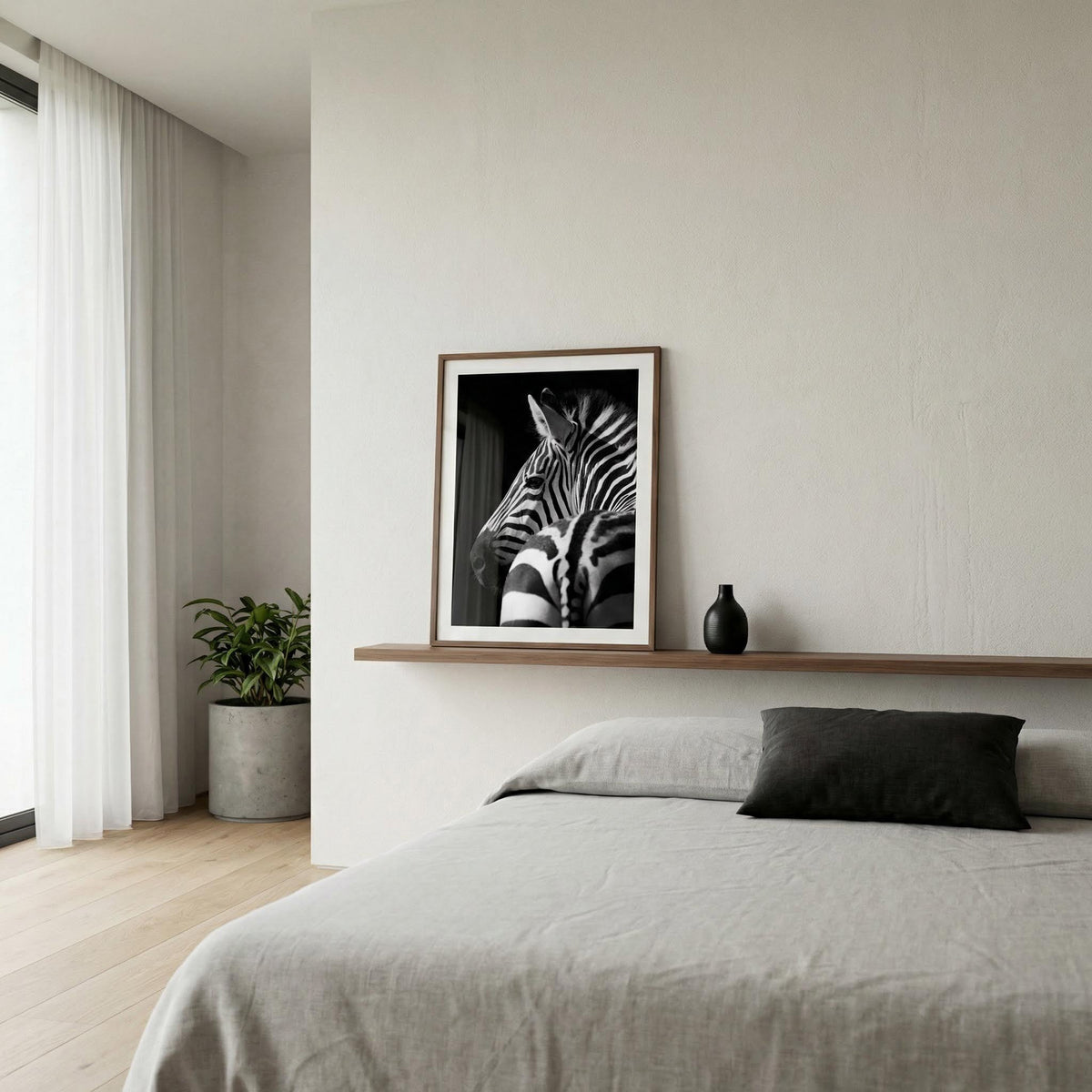 Black and white zebra print leaning on a wooden shelf above a bed with grey bedding and a plant nearby