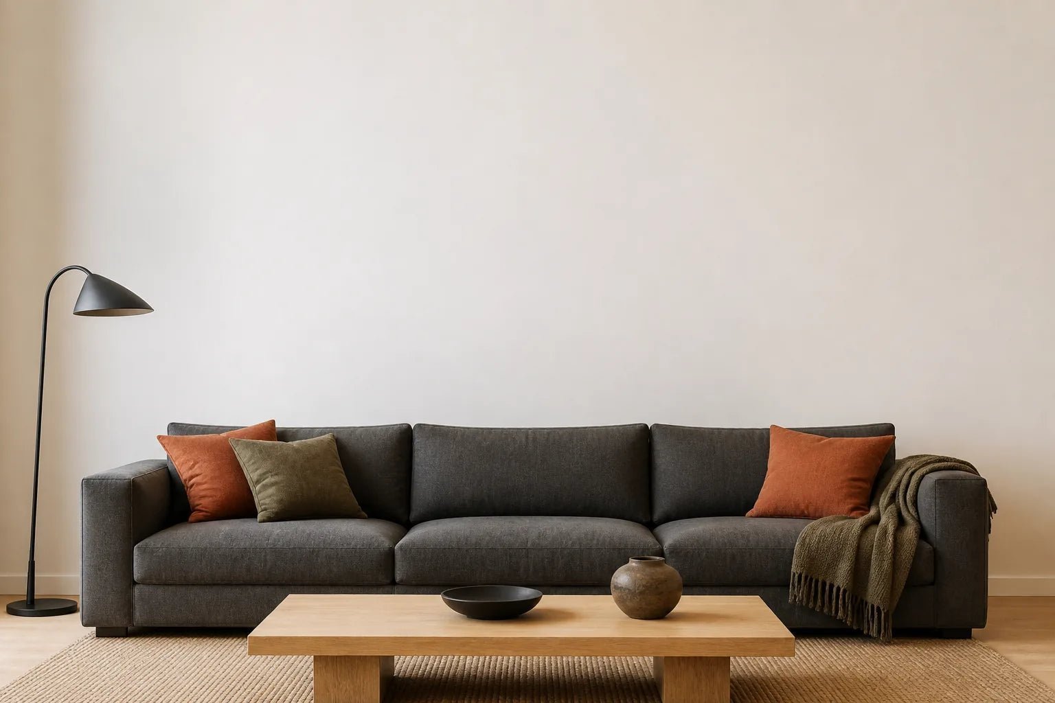 Neutrales Wohnzimmer mit einem Sofa und einer freien Wand zum Anordnen von Kunstwerken